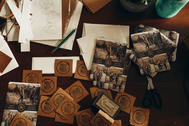 Rustic wedding invitation suite with couple photos, paper details, and natural tabletop styling.